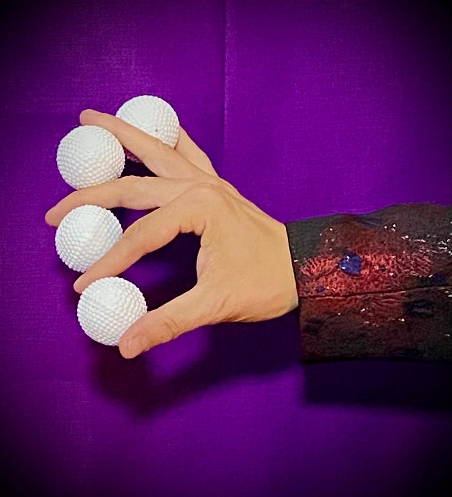 zusehen ist die Hand des ZauberRs. In ihr befinden sich (zwischen den Händen9 vier weiße Billardbälle